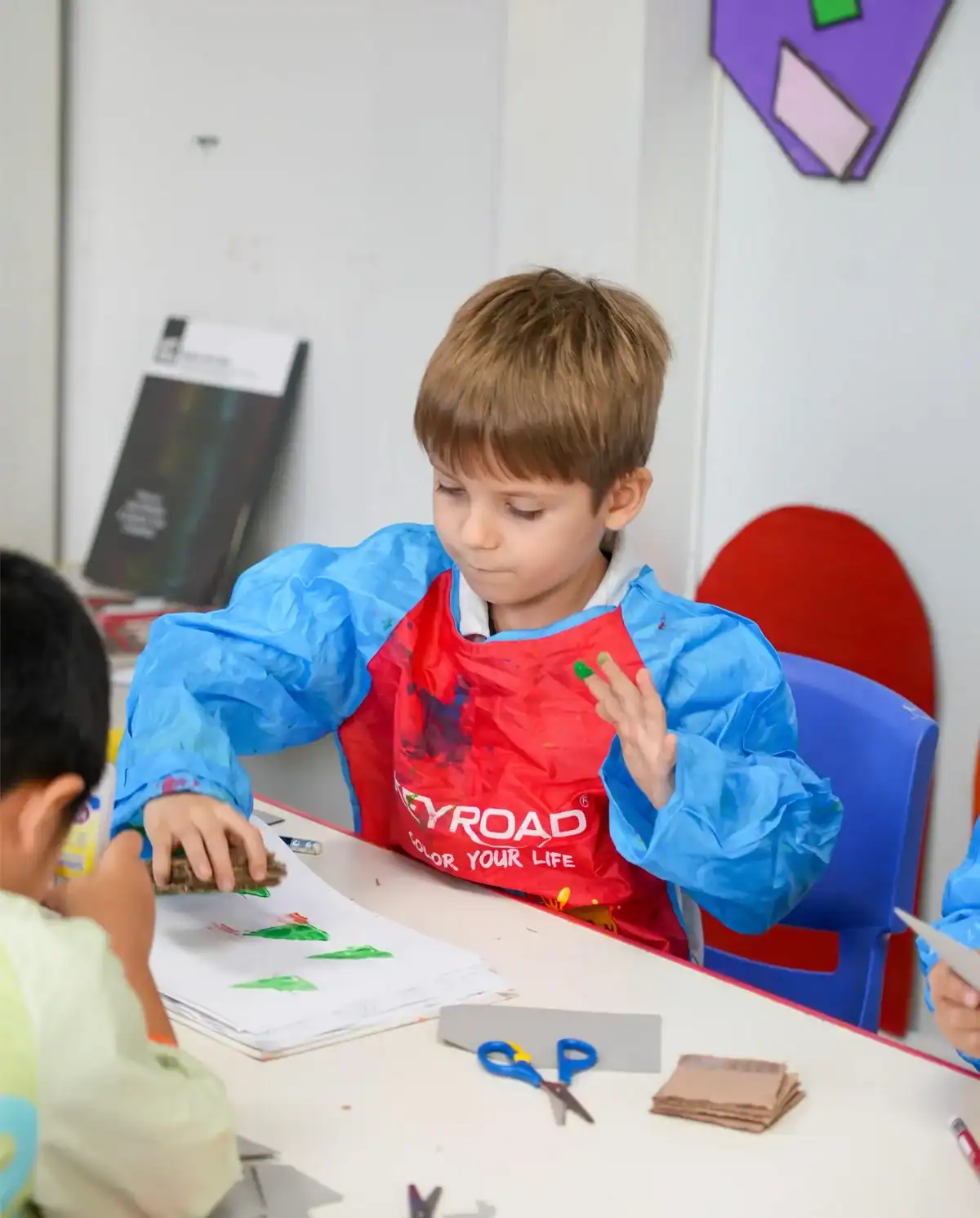 Young boy focused on art project at Boston School International.
