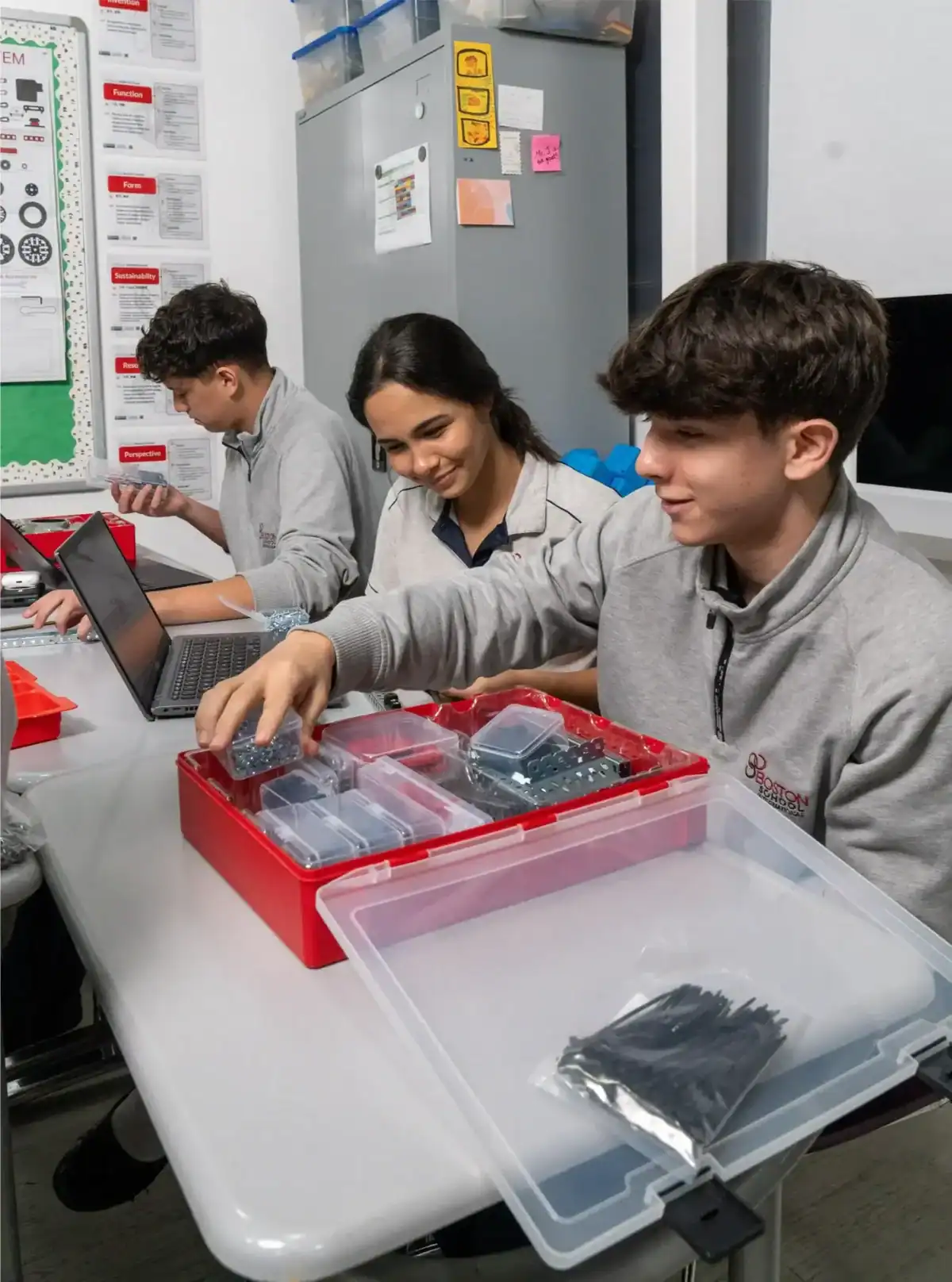 Students engaging with electronics and robotics in a classroom setting.