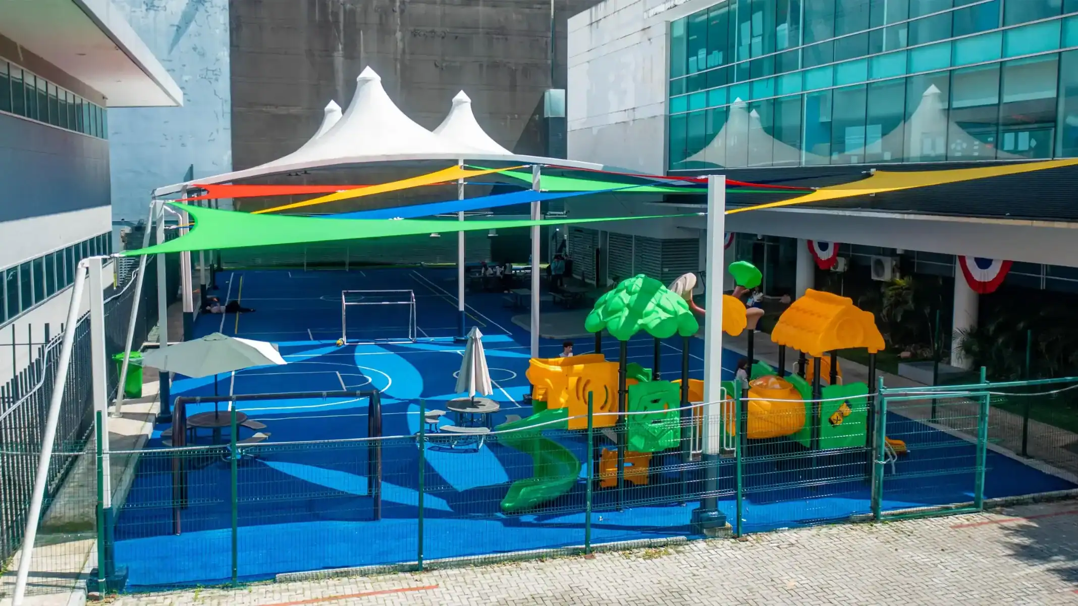 Outdoor playground with colorful slides, swings, and shaded areas for children.