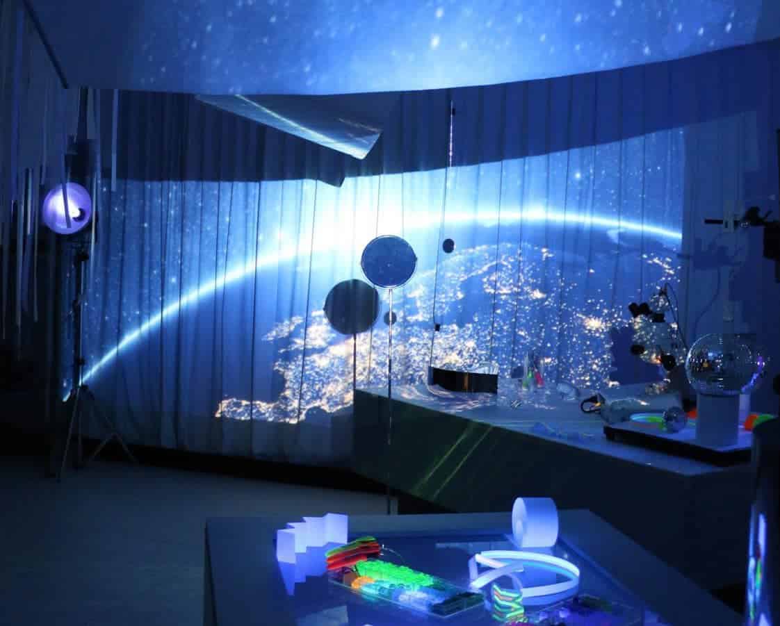 Earth from space with illuminated city lights, planets, and scientific equipment in a modern educati.