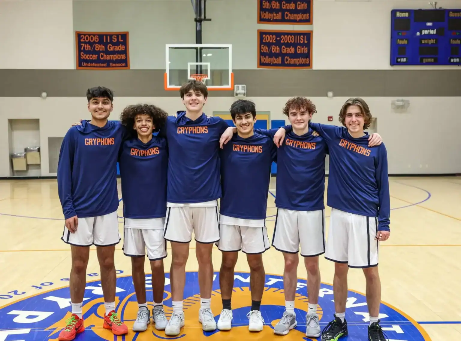 Young basketball team wearing Gryphons jerseys at school gym.