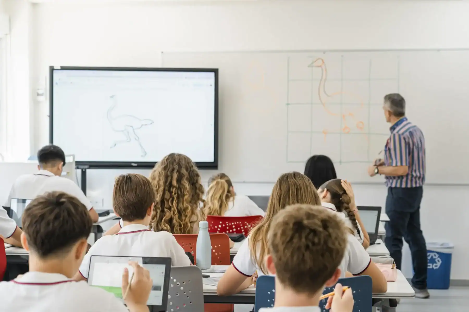 Engaging classroom scene with diverse students learning art and drawing techniques at a modern international school.