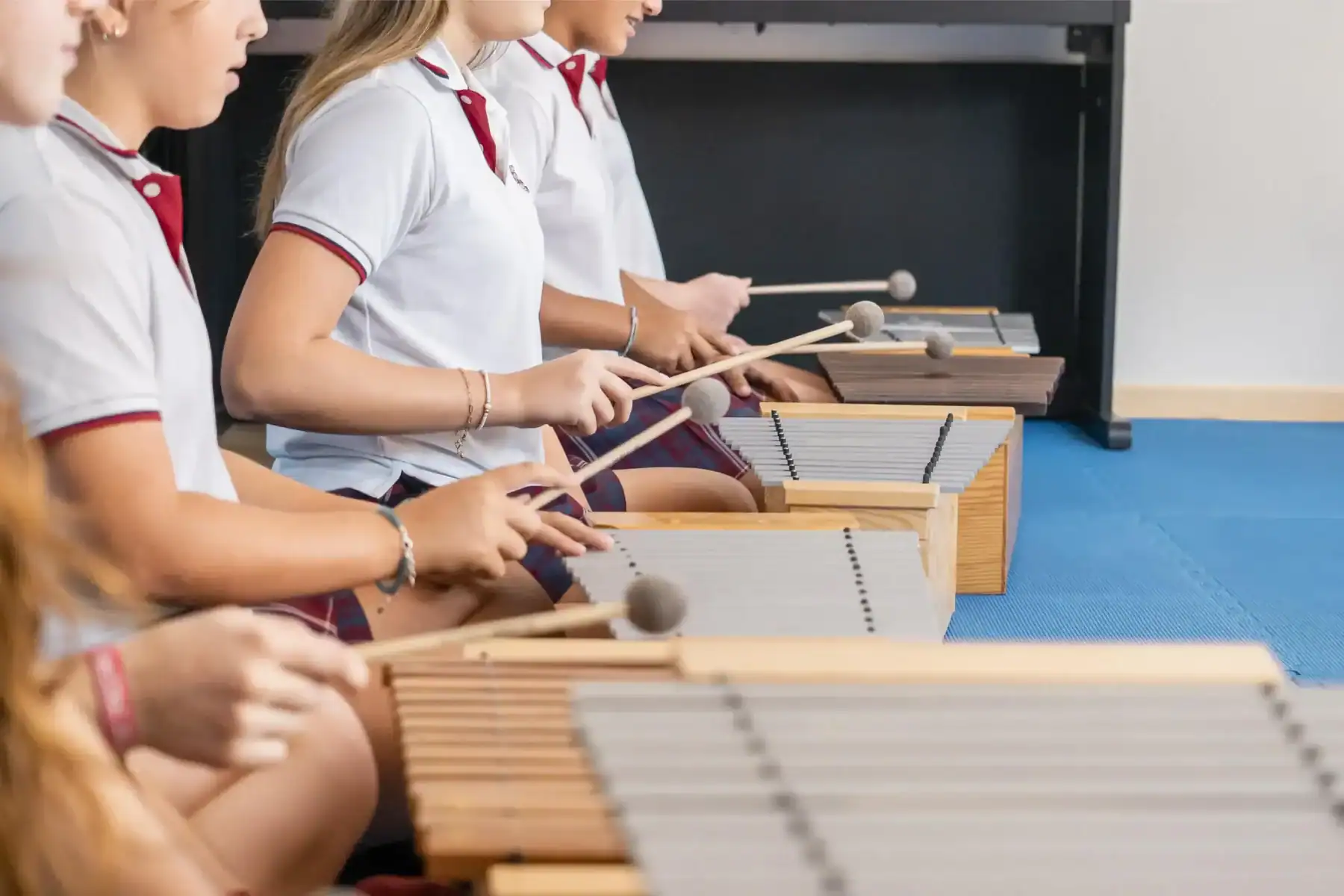 Children playing xylophones at a school music class, focusing on arts education.