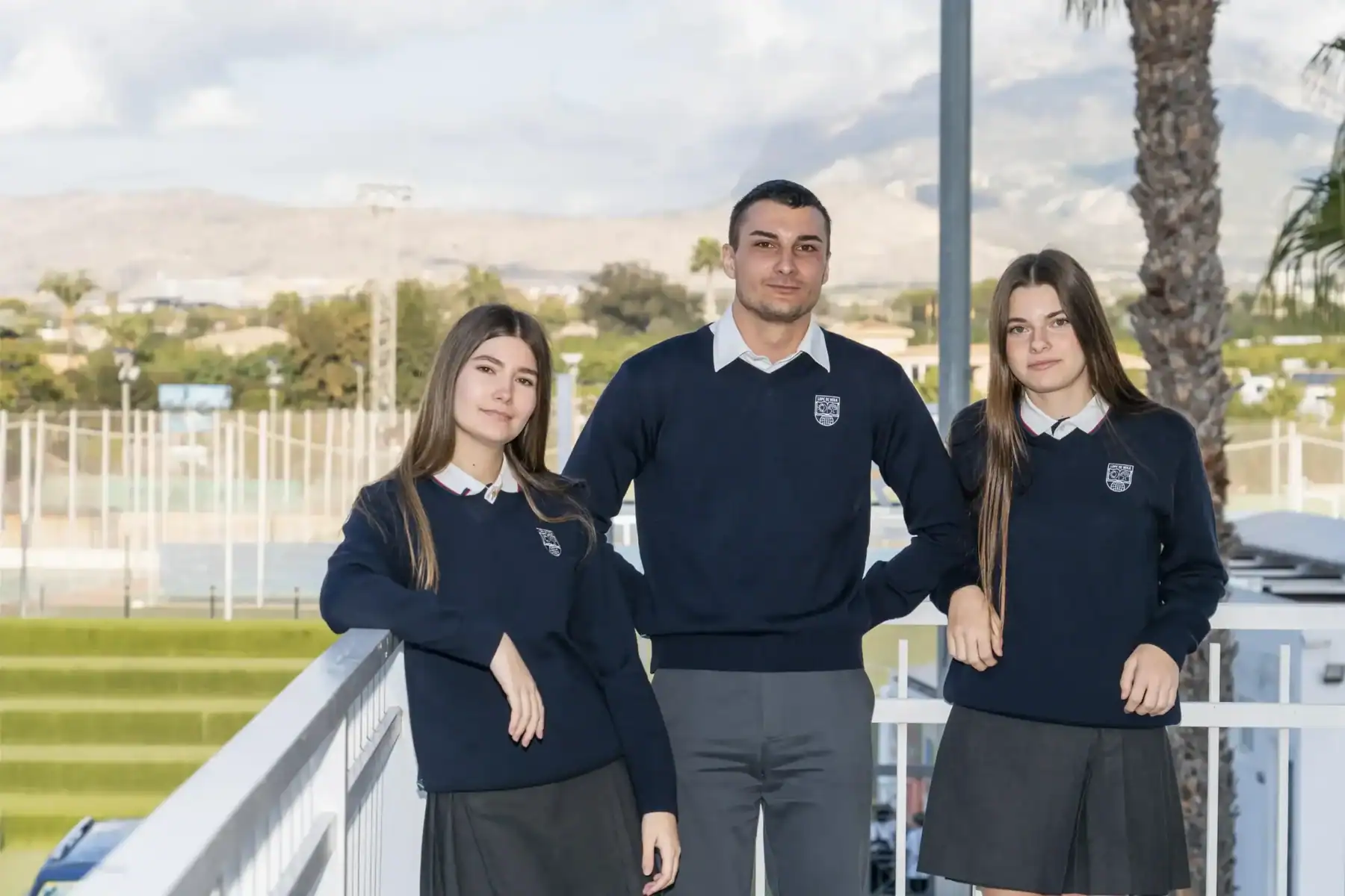 Modern students in school uniforms at an outdoor campus with scenic mountain views, highlighting international education and global student communities.