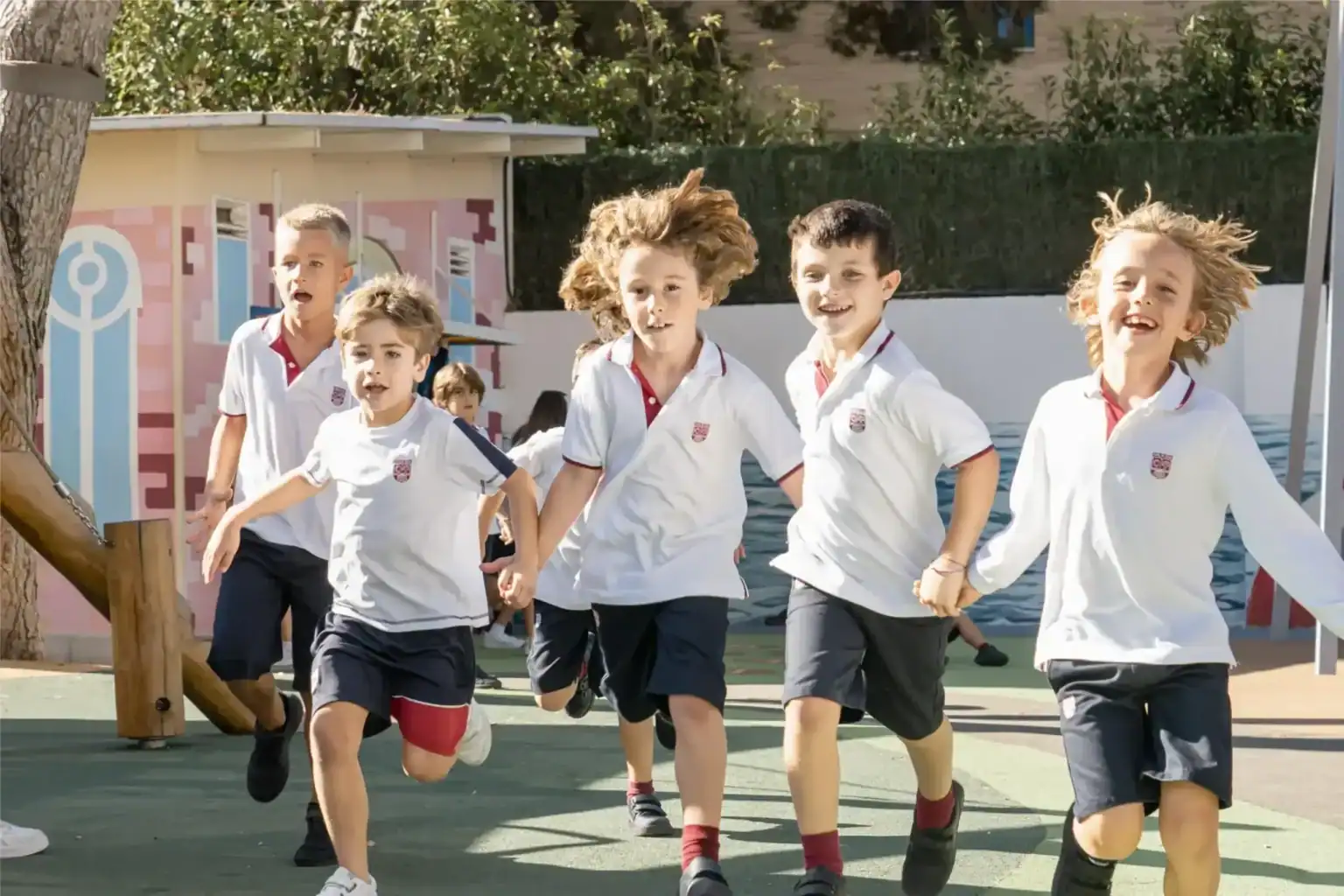Young students running and playing outdoors at a World Schools campus, promoting active learning.