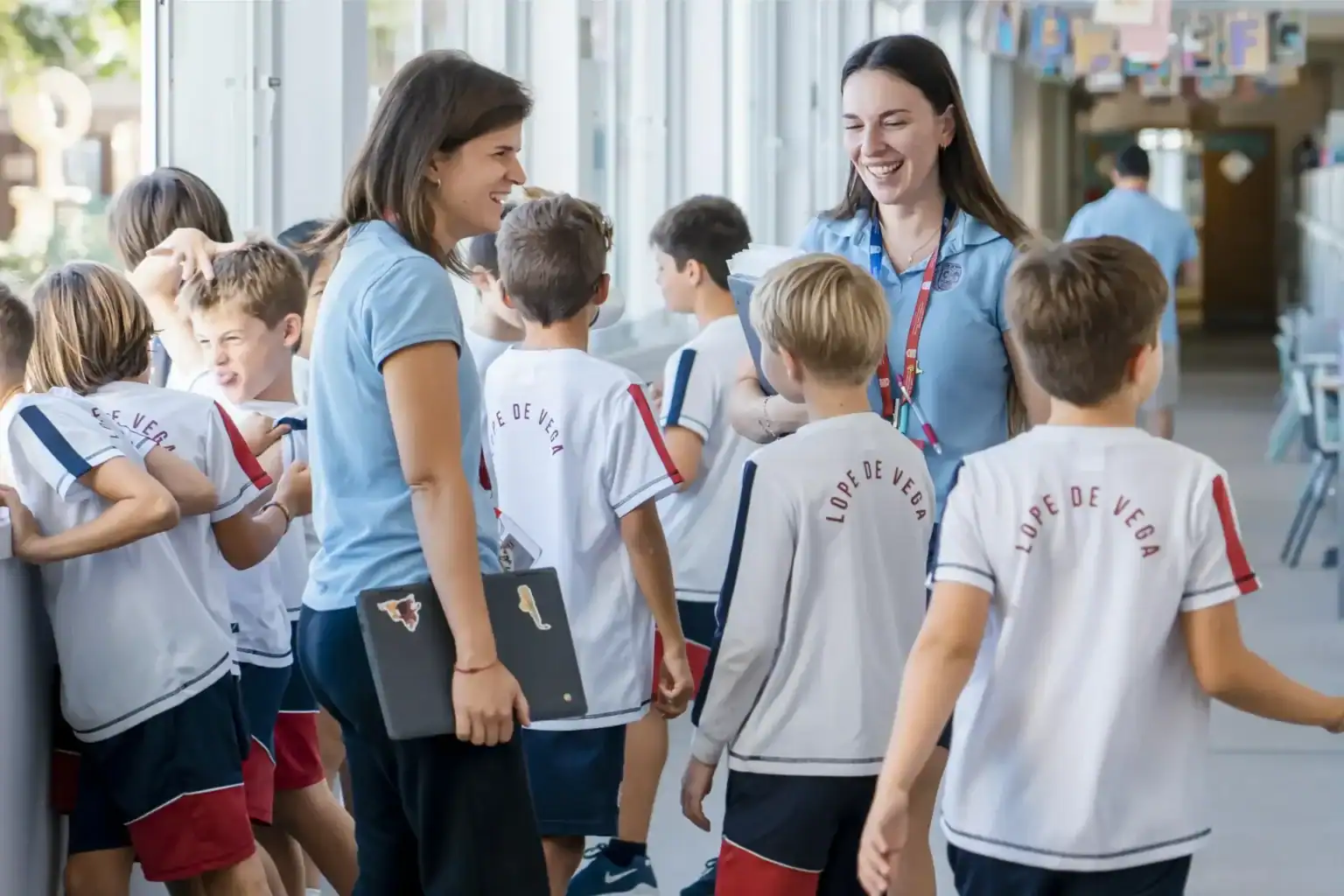 Bright school corridor with happy students and teachers in casual uniforms, promoting international education at World Schools.
