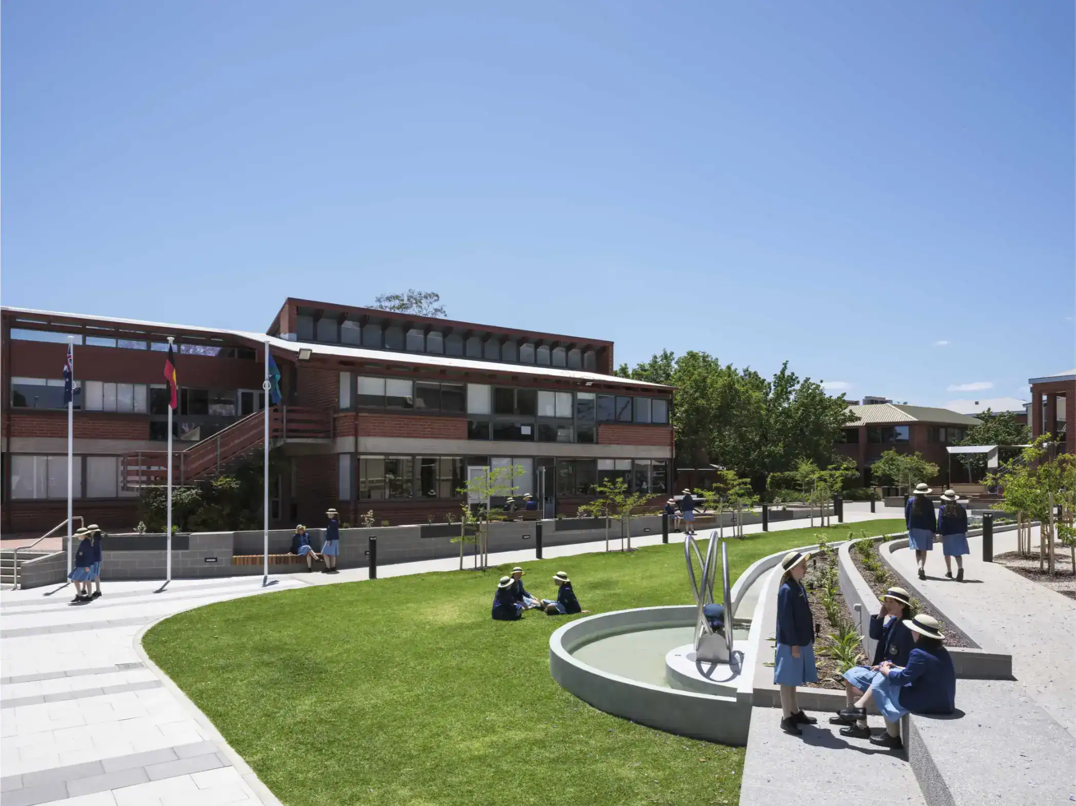 Modern school campus with students in uniforms enjoying outdoor space and green areas at a world school.