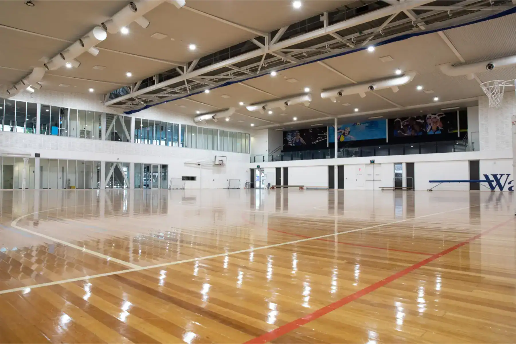 Modern indoor gymnasium with polished wooden floors, ideal for school sports and activities.