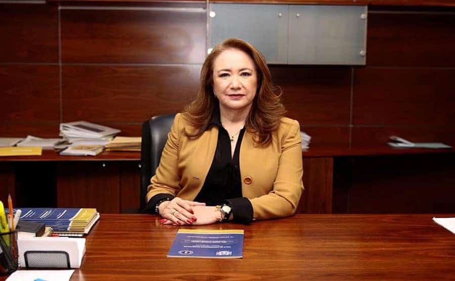 Experienced woman leader in an office setting, representing global educational leadership.