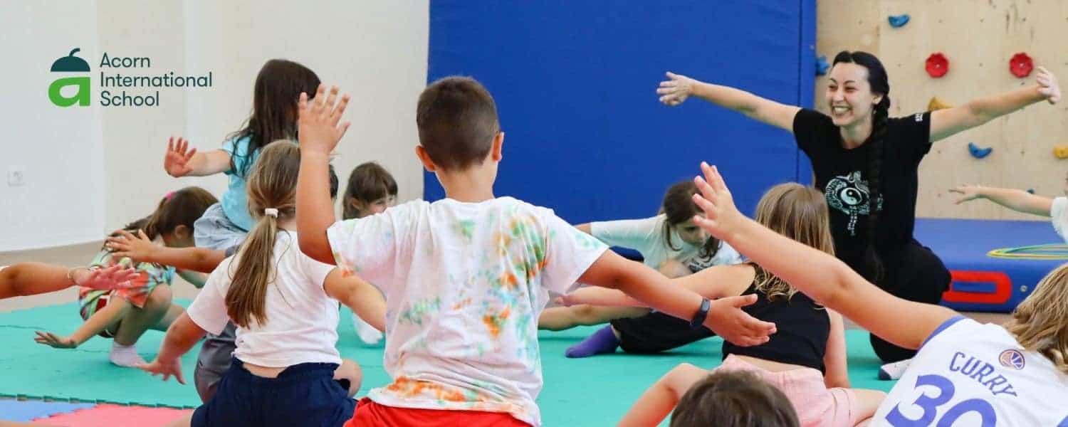 Children participating in a fun yoga class at Acorn International School for early childhood education.