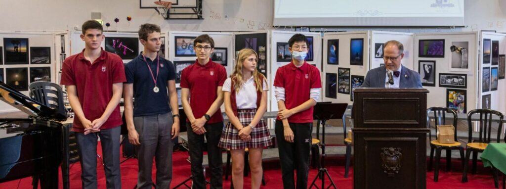 Teens participating in art exhibition at world schools event, showcasing creativity and talent in a gallery setting.