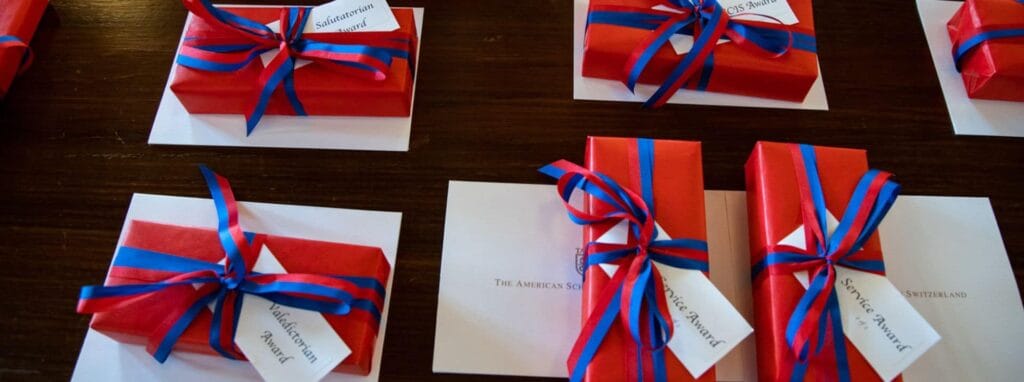 Elegant gift boxes with red wrapping and blue ribbons, representing excellence in education awards at World Schools.