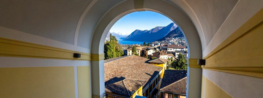 Scenic mountain view through an arched window at a top international school.