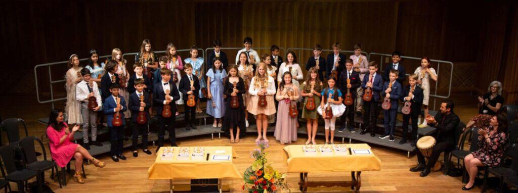 Young students performing with musical instruments at a school event, showcasing world-class education at international schools.