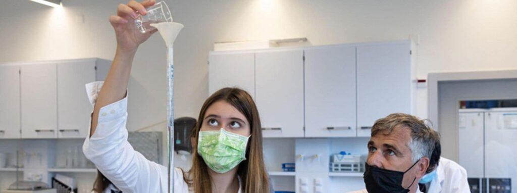 Graduating student conducting a science experiment in a classroom at World Schools.