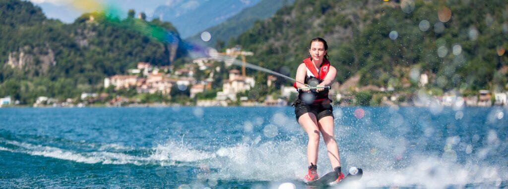 Active young woman water skiing on a scenic lake for outdoor sports and adventure.