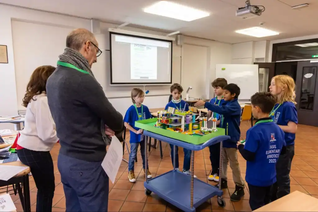 Young students presenting a robotics project at an educational workshop, focused on STEM learning and innovation.