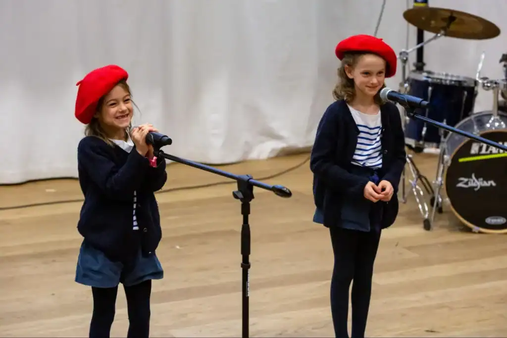 Energetic children performing on stage at a world school event, showcasing diverse global education programs and student talents.
