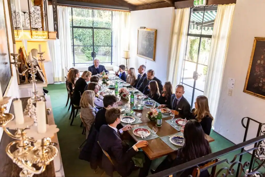 Elegant dining gathering at a historic school, showcasing world-class education and international student community.