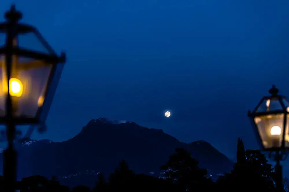 This Month at TASIS: January 2025 3 Moonlit mountain view with street lamps, peaceful educational environment.
