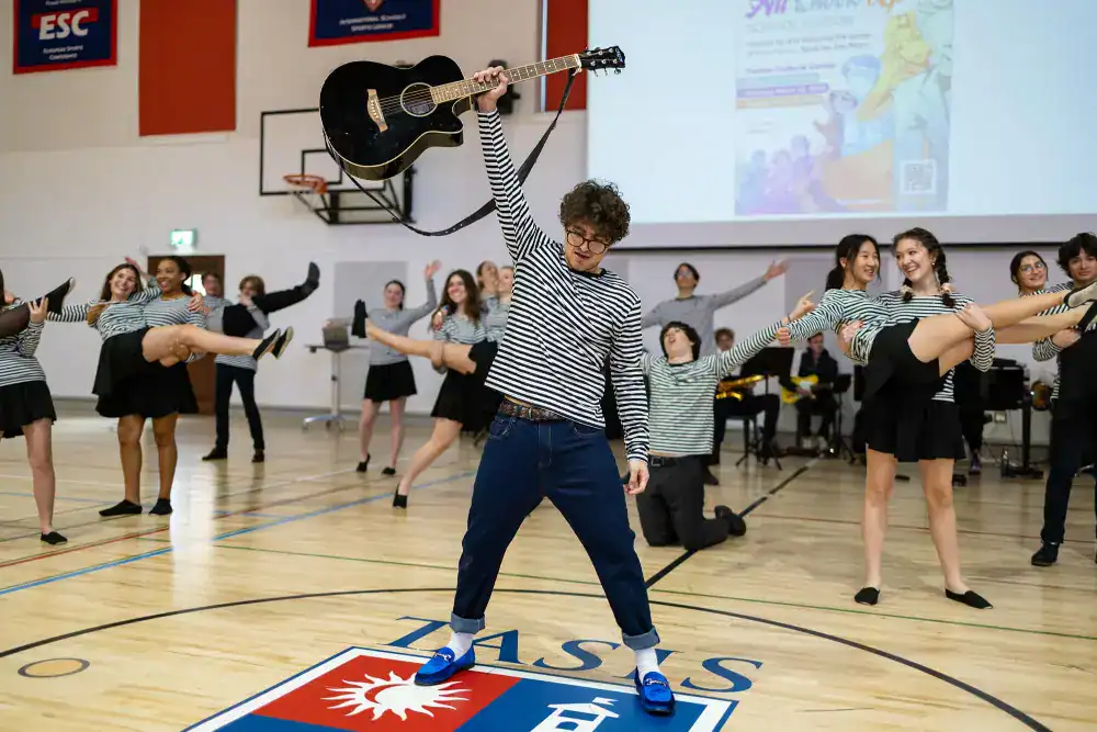 This Month at TASIS: March 2025 17 High school students performing dance and music activities in gymnasium at World Schools event.