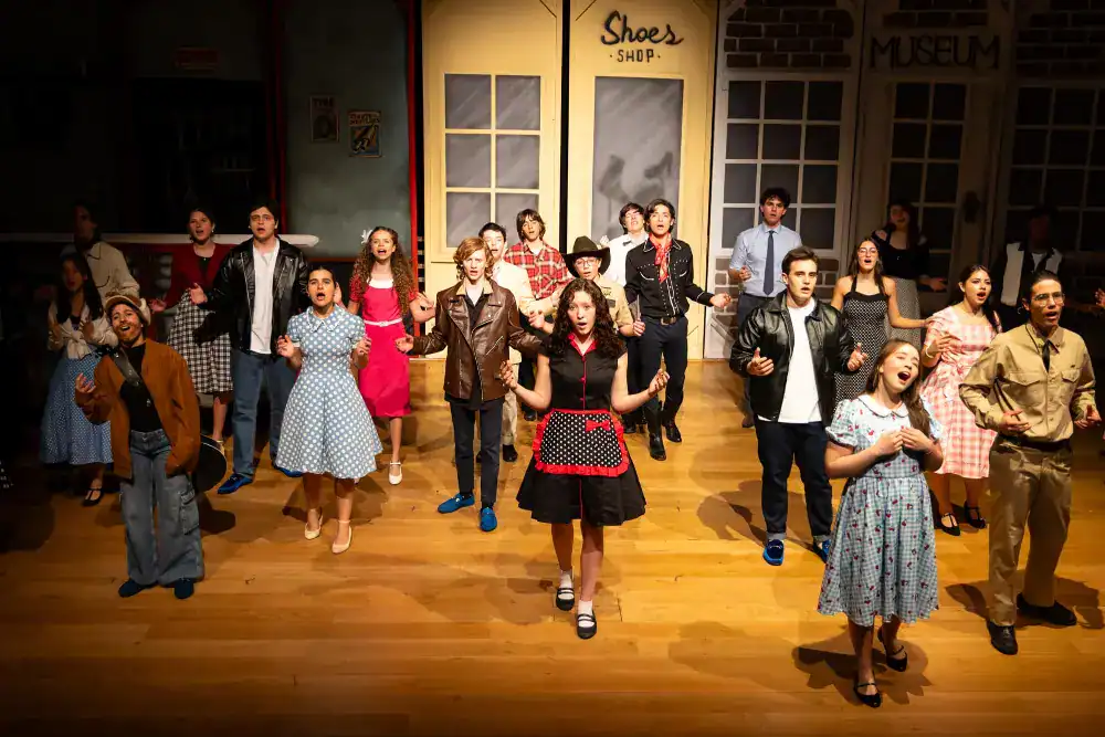 This Month at TASIS: March 2025 19 Vibrant school theater performance featuring diverse students in colorful costumes on stage.