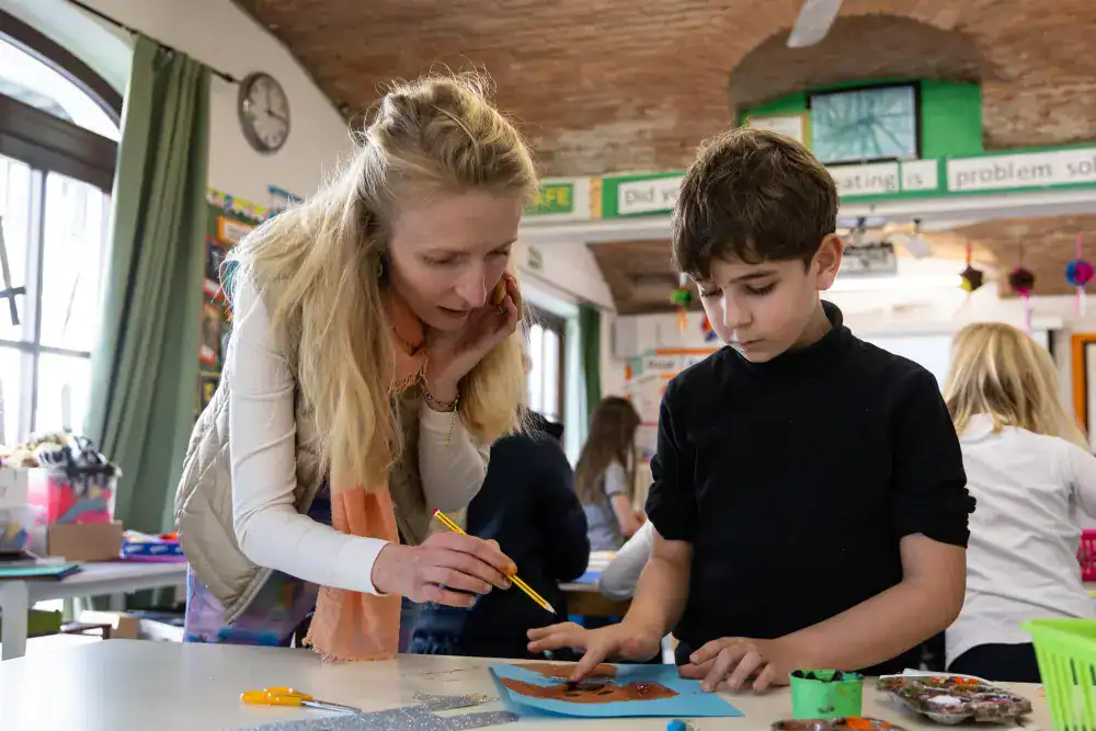 This Month at TASIS: March 2025 24 Engaging classroom scene at a world school with students and teacher in creative learning activity.