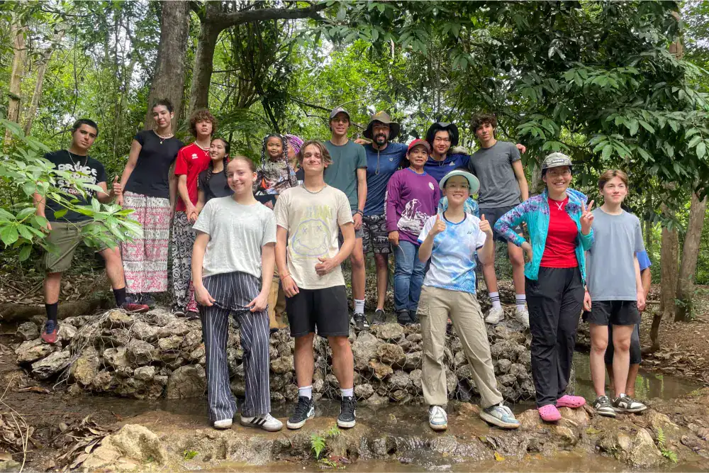 This Month at TASIS: April 2025 11 Diverse group of students and teachers on a school outdoor adventure in lush forest setting.