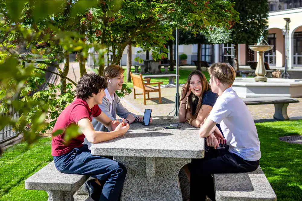 This Month at TASIS: April 2025 13 Bright students studying outdoors at a World Schools campus, fostering global education and diverse learning environments.