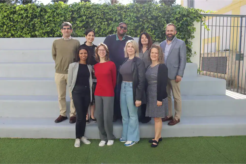 This Month at TASIS: April 2025 1 Diverse group of professionals outside at a modern school campus, showcasing international education excellence.