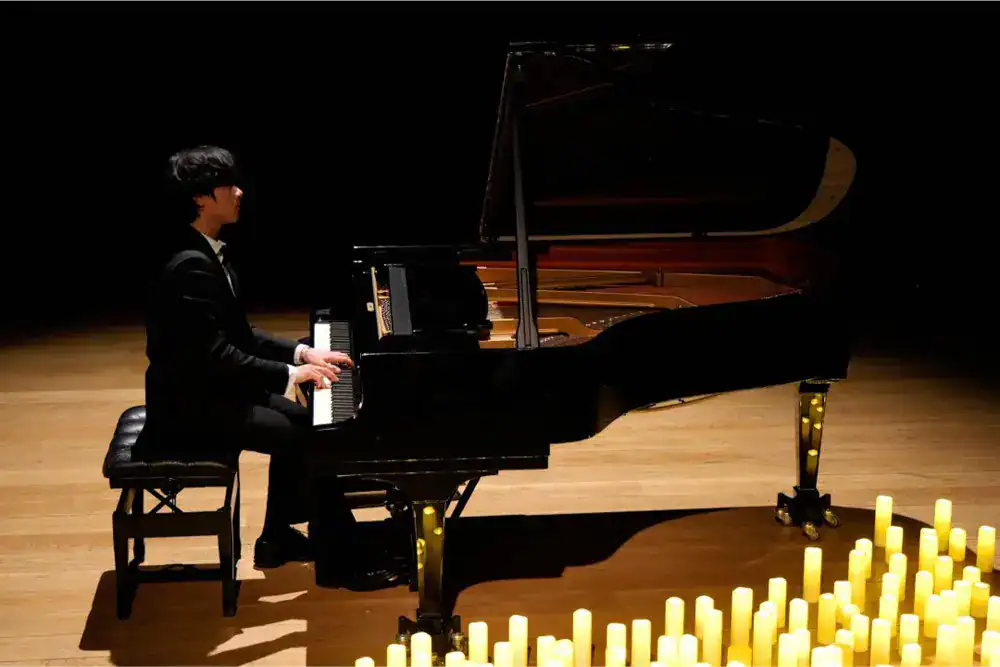 This Month at TASIS: April 2025 4 Elegant student playing grand piano on stage at World Schools event, showcasing arts education excellence.
