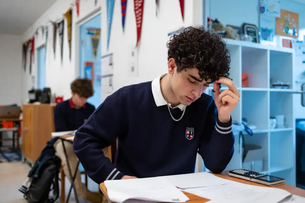 This Month at TASIS: April 2025 5 Focused student studying in a World School classroom emphasizing academic excellence and international education.
