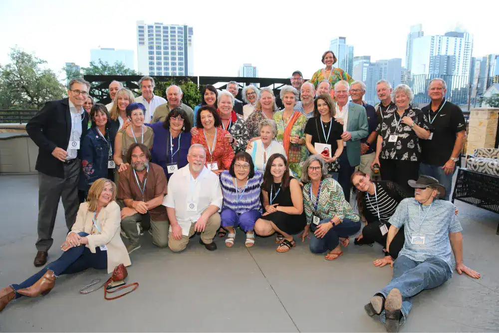 This Year at TASIS: 2024 10 Diverse group of teachers and staff at an international school conference in an urban rooftop setting.