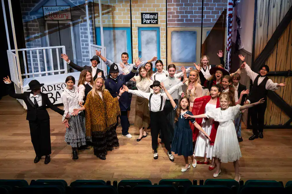 This Year at TASIS: 2024 14 Bright diverse students performing on stage at World Schools theater production for international education excellence.