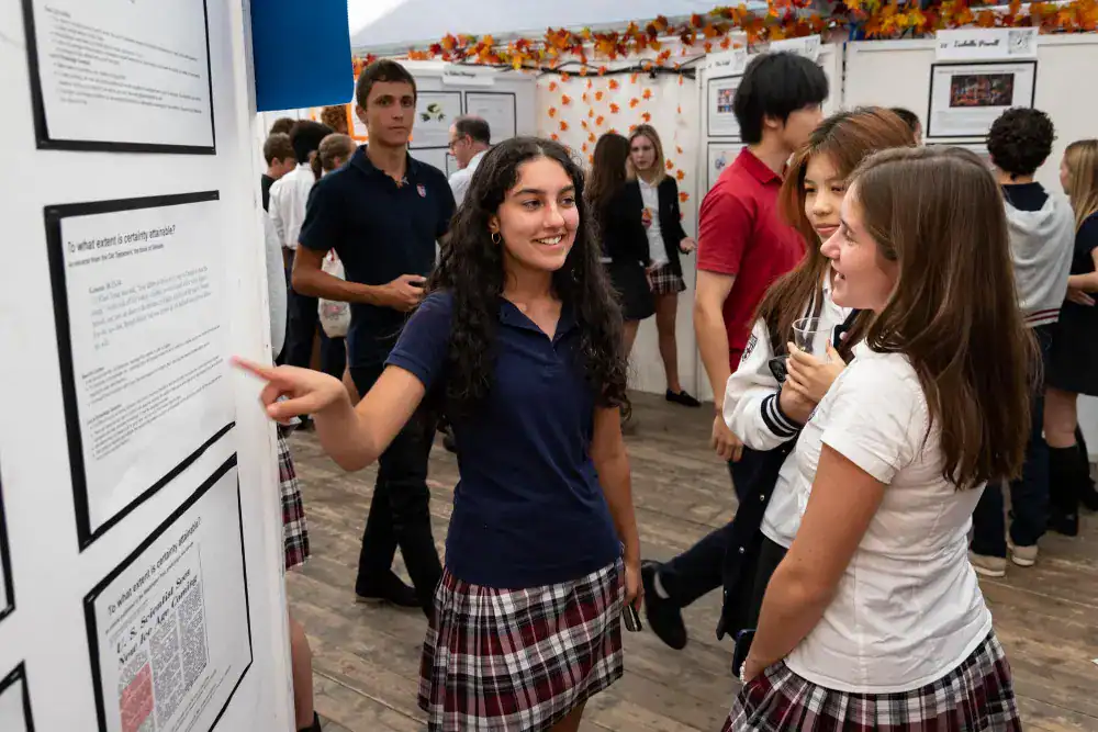 This Year at TASIS: 2024 1 High school students engaging at an academic exhibition about world schools and international education options.