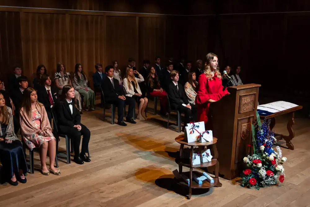 This Year at TASIS: 2024 25 Bright young students attending a World Schools graduation ceremony in an elegant auditorium.