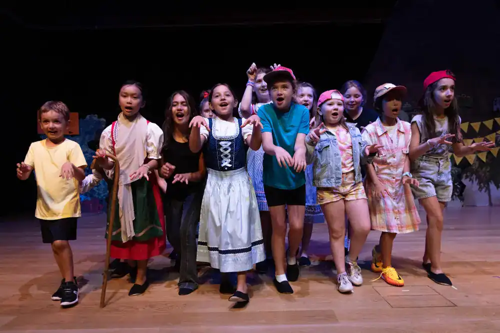 This Year at TASIS: 2024 31 Vibrant children performing on stage at World Schools arts and cultural event.