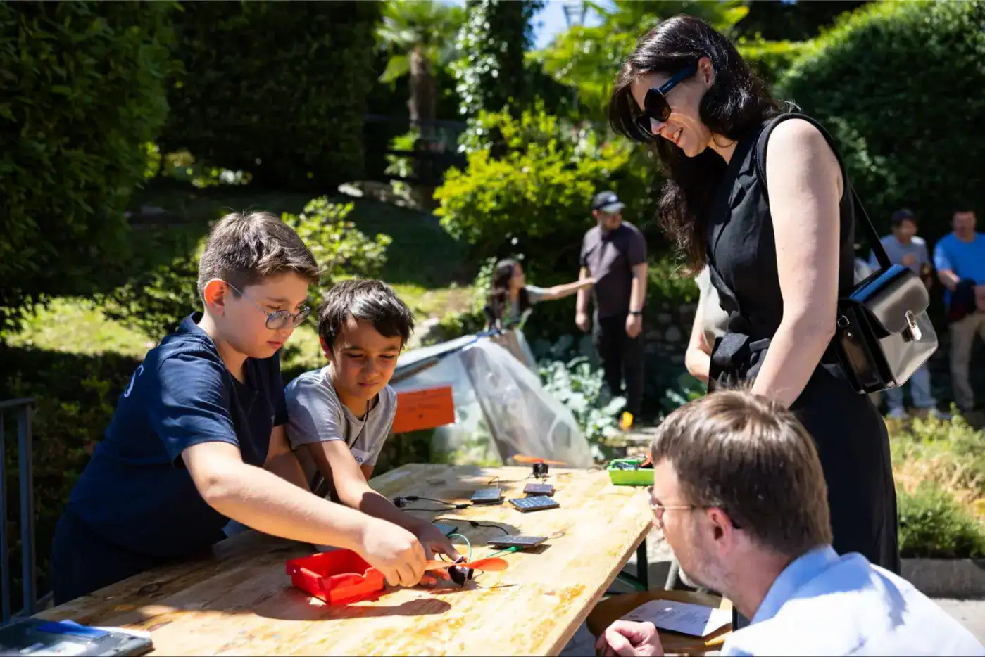 This Month at TASIS: June 2025 1 Children engaging in STEM activities at outdoor school event with teachers and peers.