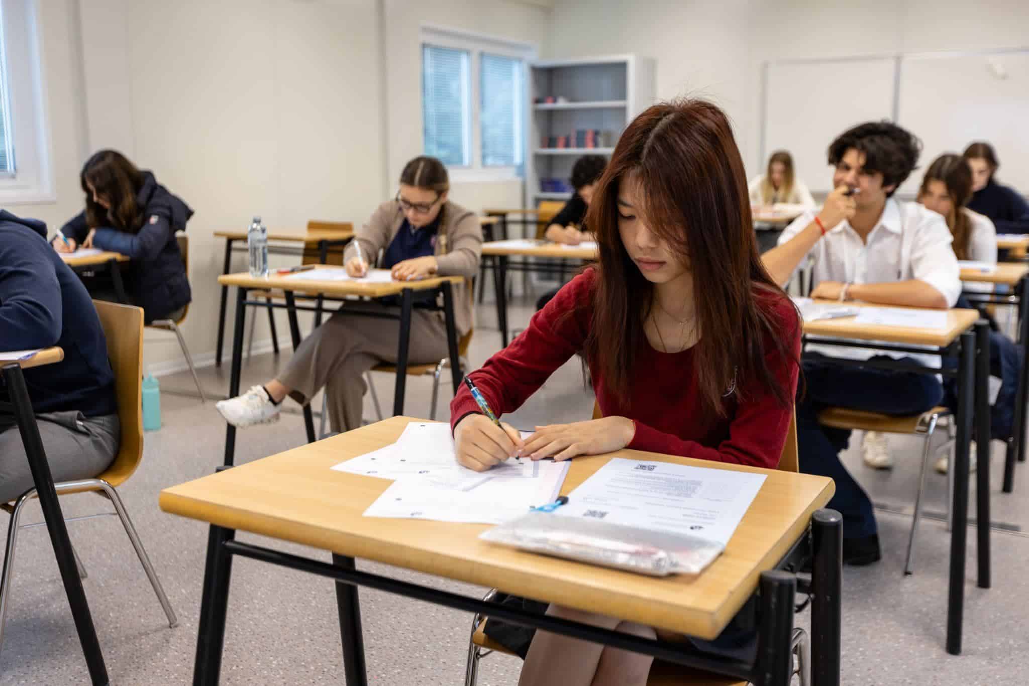 This Month at TASIS: May 2025 8 Focused student taking exam in a modern classroom at a World Schools international program.