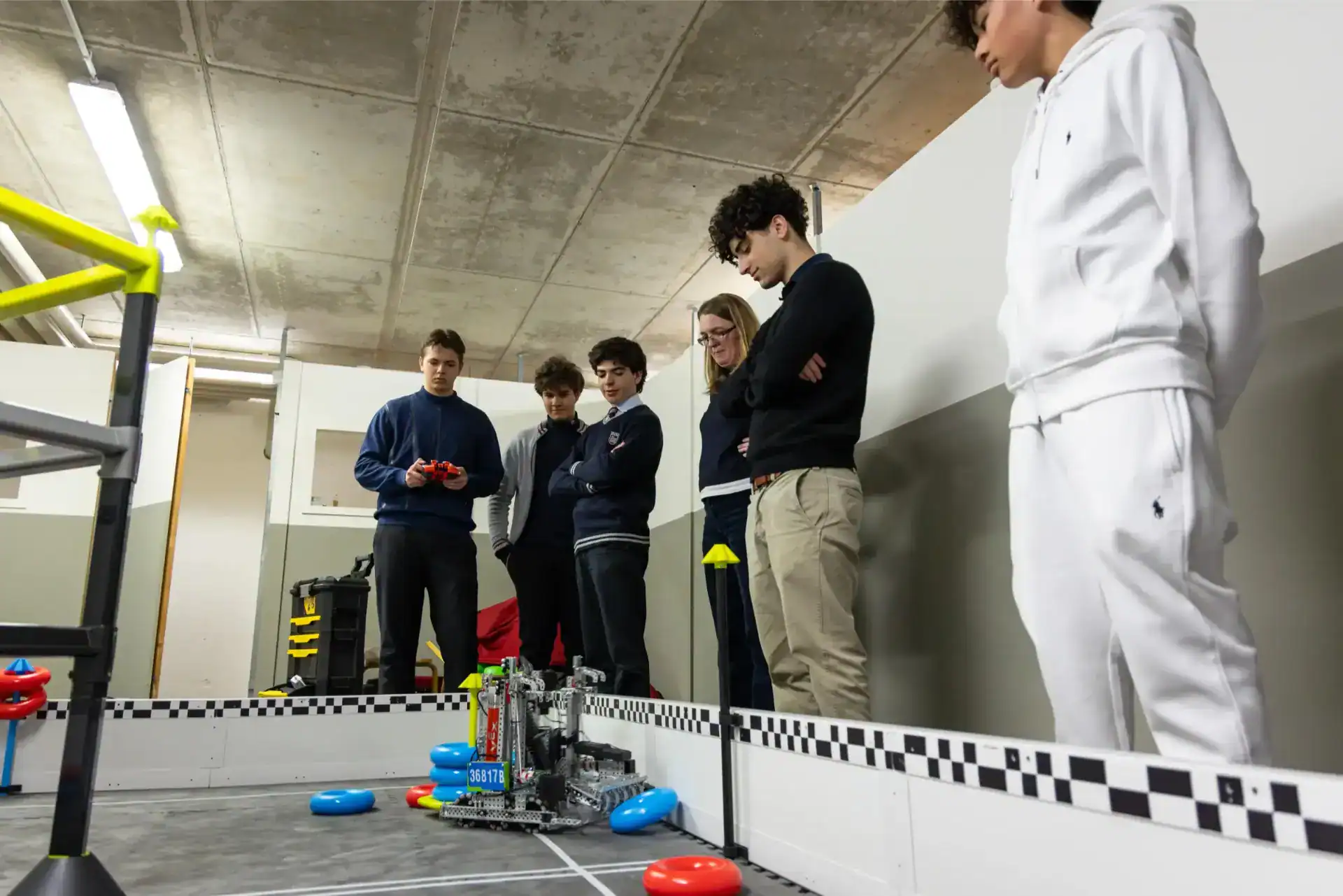 TASIS Robotics Team Heading Back to VEX World Championship 1 Robotics students building and programming a robot in a modern school lab.