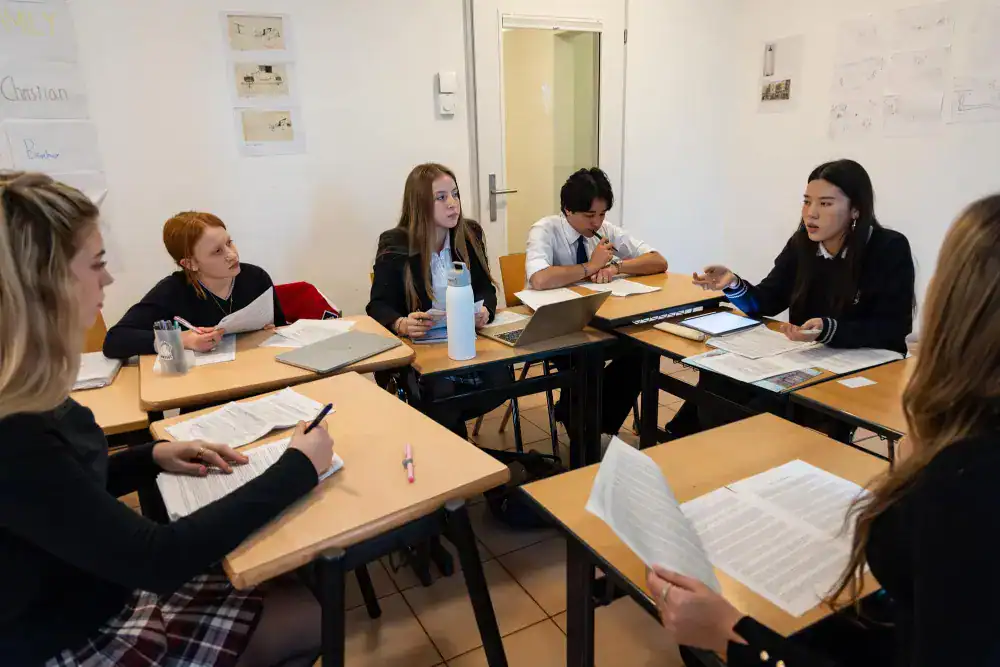 This Month at TASIS: November 2024 12 Diverse students engaging in classroom discussion at an international school, promoting global education and academic excellence.