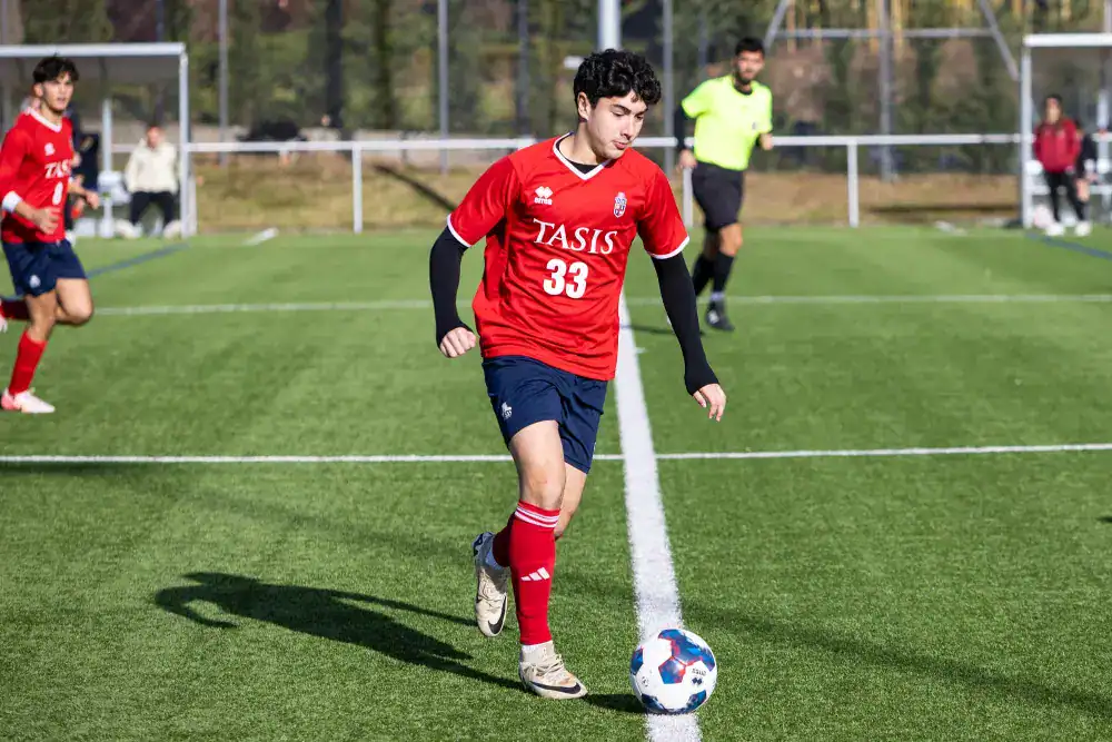 This Month at TASIS: November 2024 14 Youth soccer player preparing to kick ball on a sports field.