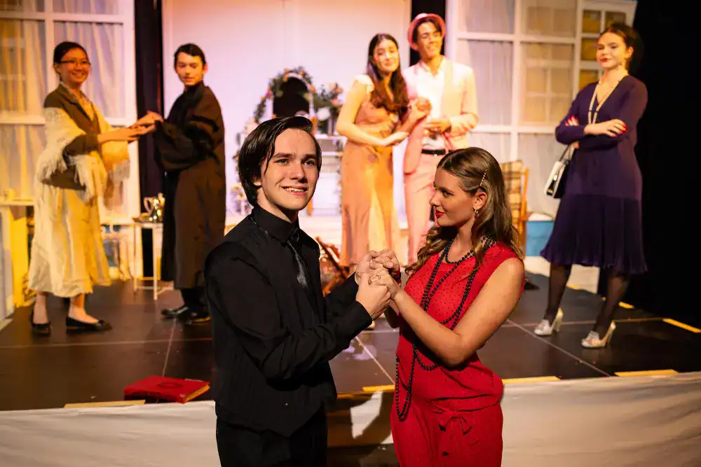 This Month at TASIS: November 2024 18 Brightly dressed students performing during a school play at a prestigious international school.