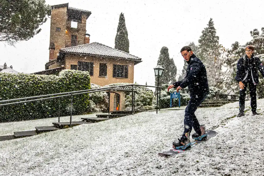 This Month at TASIS: November 2024 19 Snowboarding student at a world school in a winter setting, emphasizing outdoor education and global learning experiences.