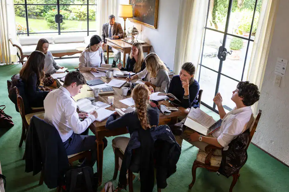 This Month at TASIS: November 2024 3 Diverse students studying collaboratively in a bright, modern classroom at a World School, fostering global learning environments.