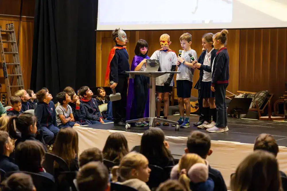 This Month at TASIS: November 2024 8 Children performing a school play on stage at an international school event.