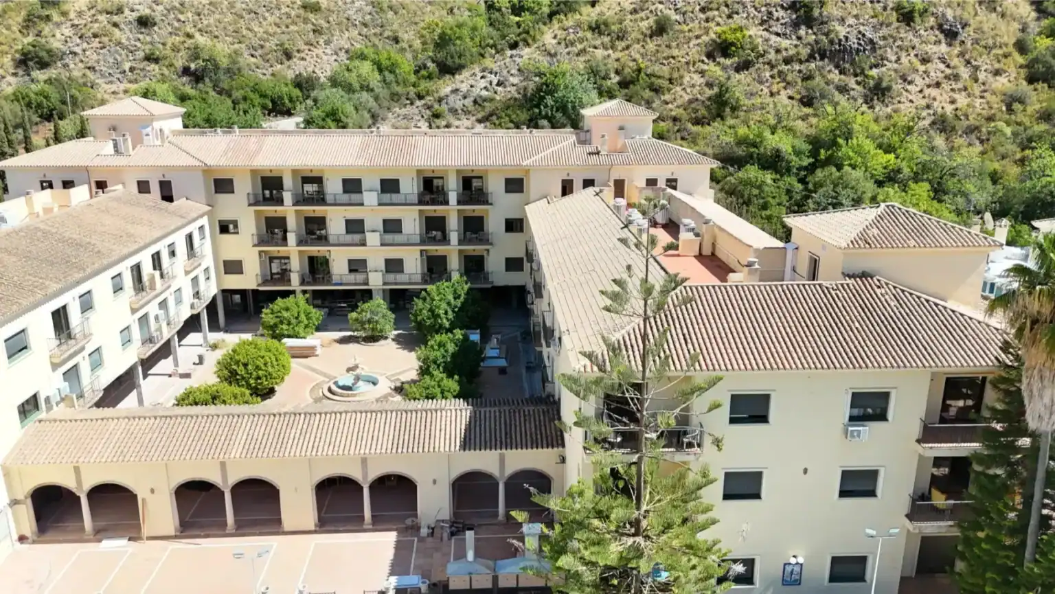 Modern school campus with Mediterranean architecture and lush green surroundings.