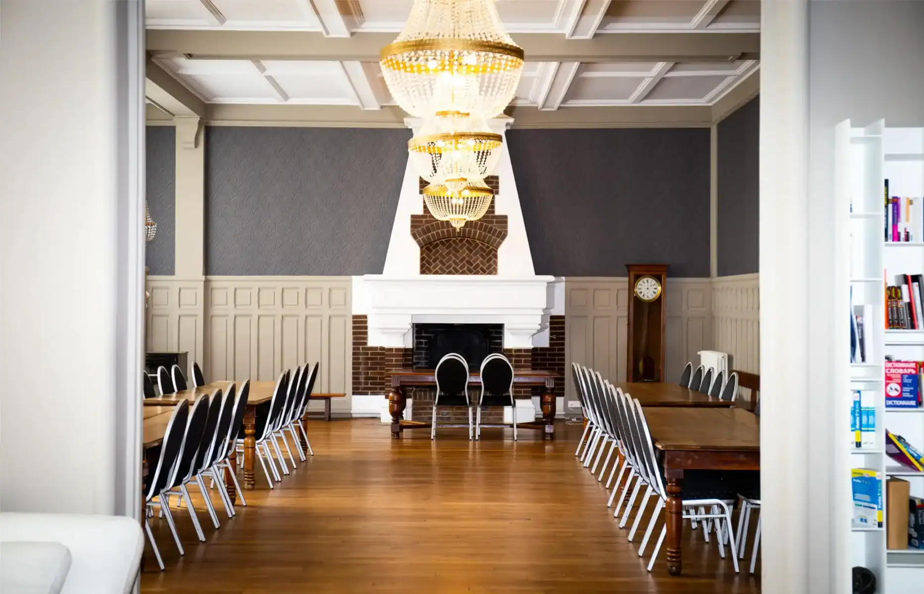 Elegant school meeting room with fireplace, chandelier, and classic furniture, ideal for world school programs.