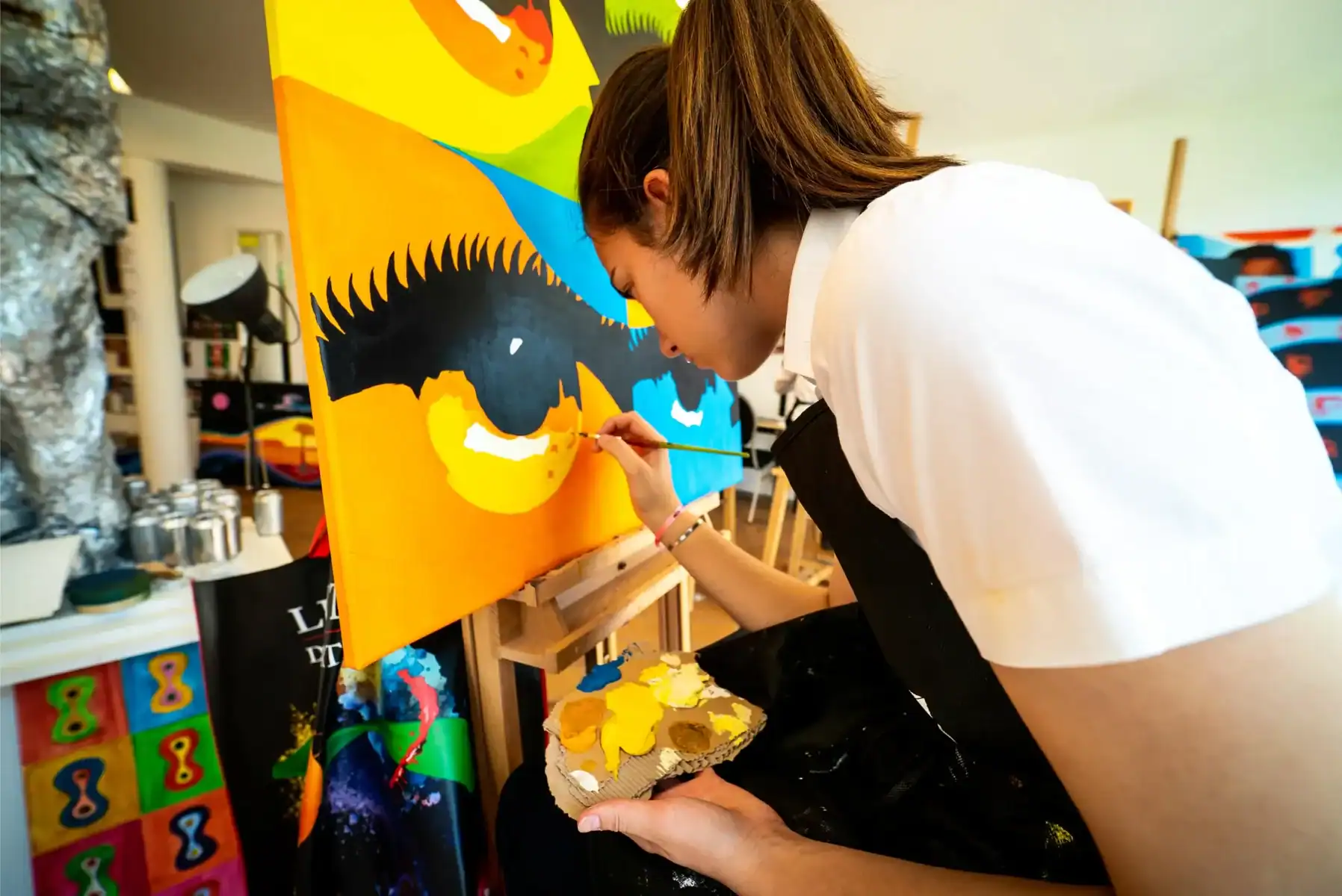 Vibrant student creating colorful mural at a global school art program.