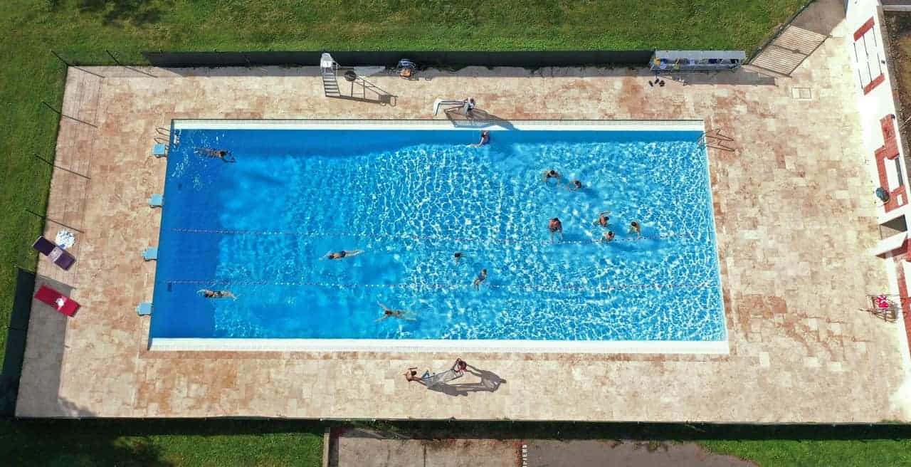 Bright outdoor swimming pool at World Schools campus with students enjoying pool activities.